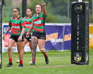 Three female NRL players, with one pointing to across the field
