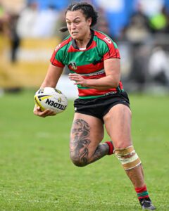 A NRL female player running with the ball